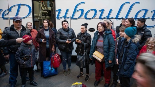 Des femmes chantent l'hymne ukrainien à la descente du bus
